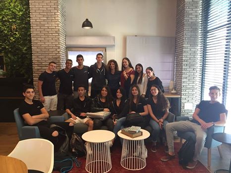 Image may contain: 15 people, people smiling, people sitting, table and indoor